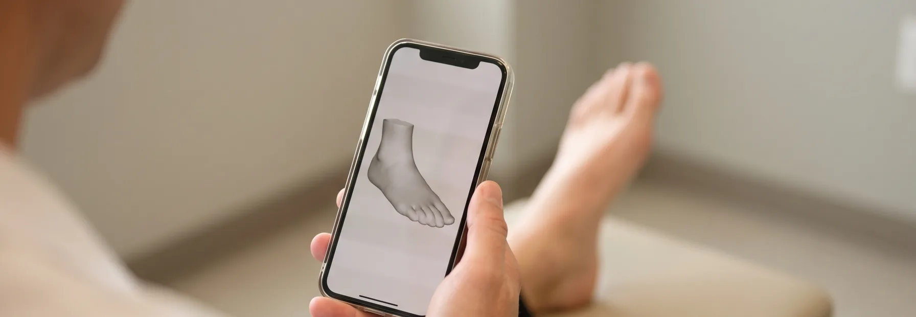 A clinician capturing a foot scan with an iPhone, the 3D preview visible on screen
